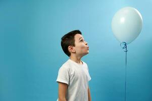 fofa estudante olhando às uma azul balão em azul fundo foto