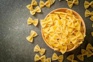 macarrão farfalle seco e cru na tigela foto