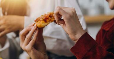 grupo do jovem amigos comendo pizza às casa e tendo Diversão foto