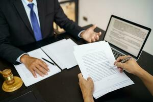 A assessoria jurídica apresenta ao cliente um contrato assinado com martelo e direito jurídico. conceito de justiça e advogado foto