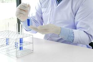 Ciência Inovativa masculino médico ou científico laboratório investigador executa testes com azul líquido dentro laboratório. equipamento Ciência experimentos tecnologia coronavírus covid-19 vacina pesquisa foto