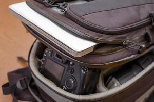 laptop e equipamento fotográfico profissional na mochila foto