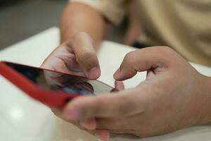 relaxado jovem ásia homem usando inteligente telefone gastos Tempo verificação notícia social meios de comunicação. foto