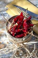 uma tigela do vermelho Pimenta pimentas em uma mesa foto