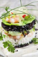 torre de arroz preto e branco com camarão e abobrinha foto