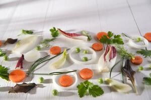 uma branco mesa com cenouras, cebolas, salsão e salsinha foto