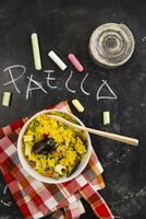 arroz com mexilhões e legumes em uma Preto toalha de mesa com quadro-negro arroz foto