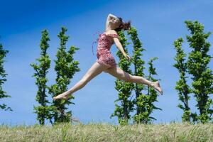 menina pulando dentro natureza dentro Primavera estação foto