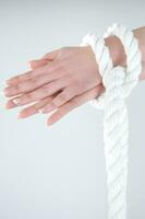 uma mulher mãos estão amarrado para uma corda foto