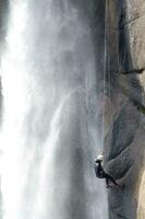 uma pessoa em uma corda escalada acima uma cascata foto