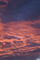 uma vermelho e laranja céu com nuvens foto