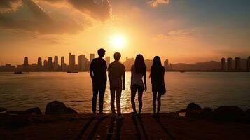 grupo do quatro alunos uma Garoto e uma menina apreciar e capturar momentos às oeste Kowloon beira-mar passeio hong kong às pôr do sol foto