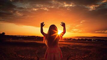 pequeno menina formando coração às pôr do sol a partir de atrás foto