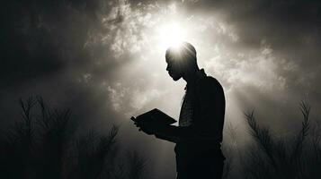 uma homem detém uma Bíblia ora dentro Preto e branco com uma luz flare foto