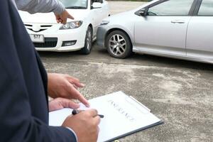 perda ajustador seguro agente inspecionando estragado carro. foto