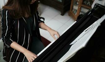 lindo mulher jogando piano, aprender para jogar piano. foto