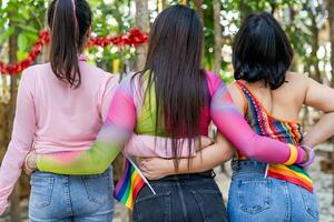 feliz amigos lgbtq transgêneros ásia mulher LGBTQIA segurando cada de outros dentro verão Festa. amizade conceito foto
