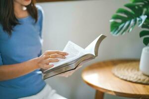 mulheres lendo livro e relaxante às casa e conforto dentro frente do aberto livro foto