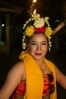 uma tradicional javanese dançarino danças com colorida flores em dela punho enquanto em etapa foto