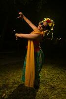uma tradicional indonésio dançarino dançando com a corpo torção em etapa foto