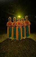 uma grupo do indonésio tradicional dançarinos dança com seus amigos dentro frente do a etapa luzes foto