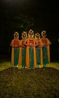 uma grupo do indonésio tradicional dançarinos dança com seus amigos dentro frente do a etapa luzes foto