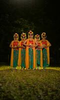 uma grupo do tradicional javanese dançarinos em pé dentro fantasias e laranja xales e oculos de sol em seus olhos foto