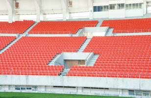 esvaziar laranja assentos às estádio, linhas passarela do assento em uma futebol estádio foto