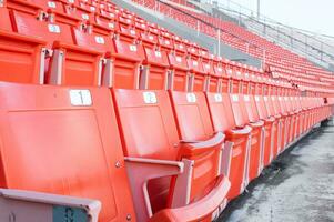 esvaziar laranja assentos às estádio, linhas do assento em uma futebol estádio foto