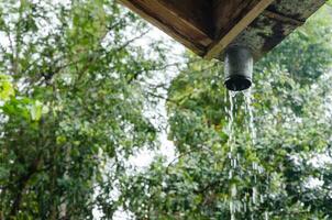 chuva derramando baixa a partir de calha foto