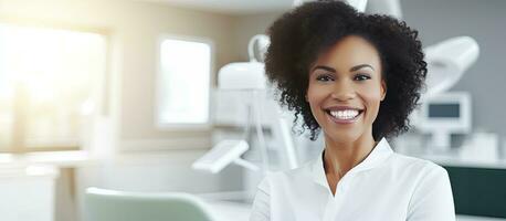 Preto fêmea dentista sorridente às Câmera dentro clínica paciente esperando esvaziar área foto