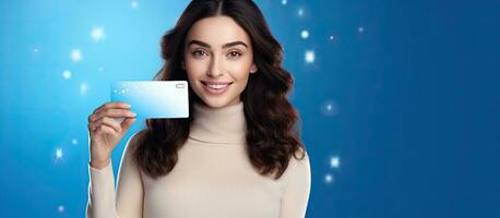 lindo jovem mulher segurando em branco presente cartão em azul fundo foto