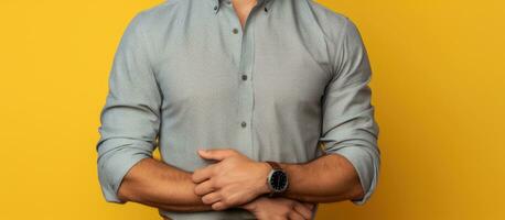 uma branco homem dentro uma cinzento camisa posando dentro uma estúdio com uma amarelo fundo dele Palma exibindo a esvaziar espaço e dele de outros mão em dele cintura foto