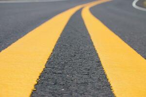amarelo curvado tráfego linha em a autoestrada, fechar acima. foto