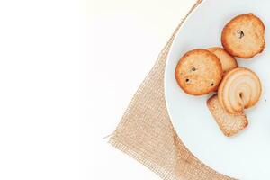 manteiga biscoitos dentro uma branco prato em uma branco fundo. foto