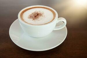 café copo do cappuccino em de madeira mesa dentro cafeteria foto