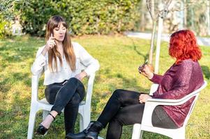 meninas fumando cigarro eletrônico no jardim foto