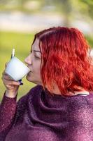 menina bebendo uma xícara de chá no jardim