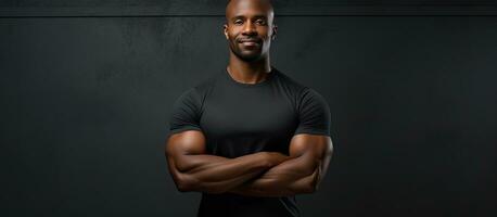 africano americano ginástica treinador com confiança poses com cruzado mãos foto