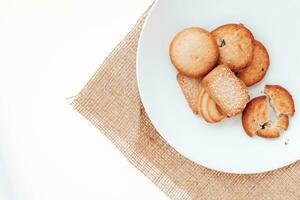 manteiga biscoitos dentro uma branco prato em uma branco fundo. foto