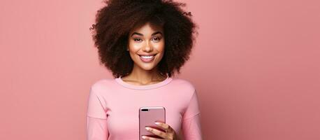 africano americano mulher segurando telefone Rosa fundo conectados compras conceito foto