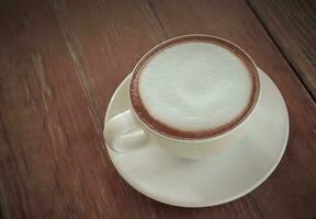 cappuccino café copo em a de madeira mesa foto