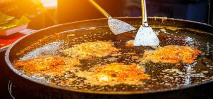 tailandês crocantes frito mexilhão panquecas cozinhou dentro uma quente frigideira, uma famoso rua Comida dentro tailândia. a nome é Hoi tod, tailandês Comida às noite. foto