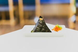 japonês onigiri tradicional Comida dentro triângulo forma embrulho com algas marinhas. foto