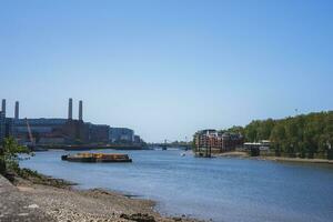 Battersea poder estação às bancos do Tamisa rio com azul céu dentro fundo foto