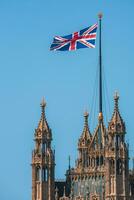 Reino Unido bandeira com grande ben e casa do parlamento dentro a fundo foto