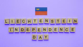 agosto 15, liechtenstein independência dia, liechtenstein nacional dia, liechtenstein bandeira, minimalista bandeira com a inscrição dentro de madeira cartas em uma azul fundo foto