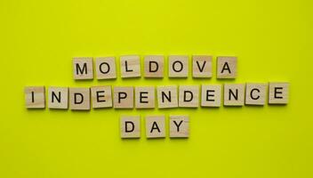 agosto 27, Moldova independência dia, minimalista bandeira com a inscrição dentro de madeira cartas foto