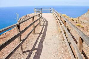 uma passarela com uma de madeira cerca conduz para a oceano foto