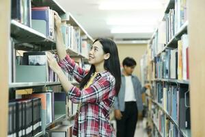 universidade alunos arte escolhendo livro dentro campus biblioteca. foto